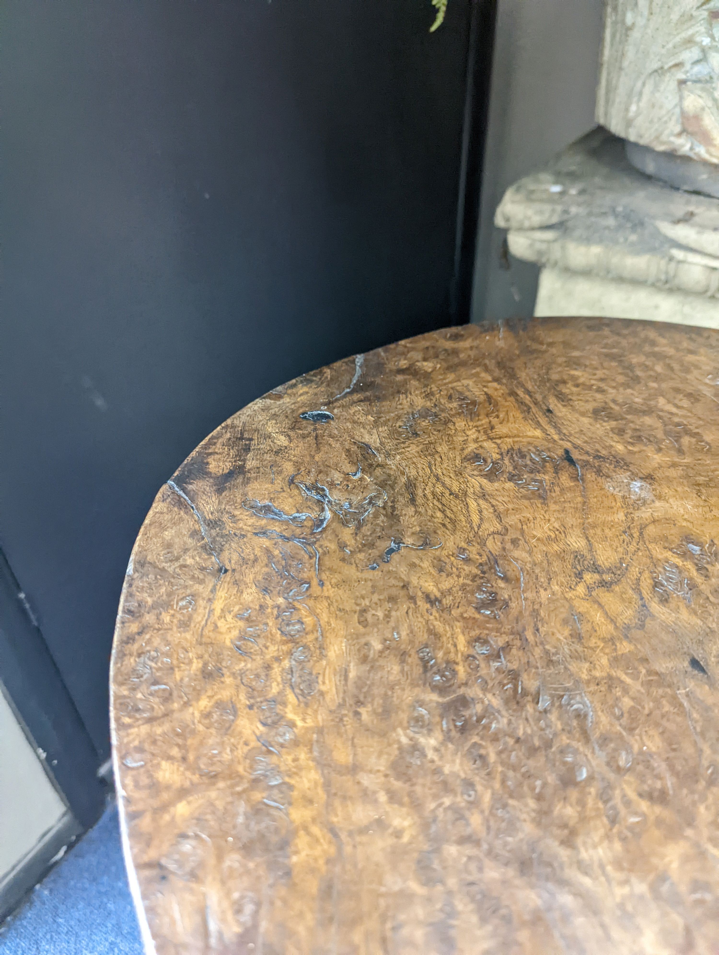 A circular burr elm and ash primitive cricket table with T shaped stretcher, diameter 44cm, height 61cm